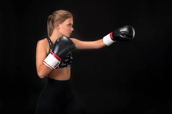 Hermosa atleta femenina en guantes de boxeo, en el estudio sobre un fondo negro . — Foto de Stock