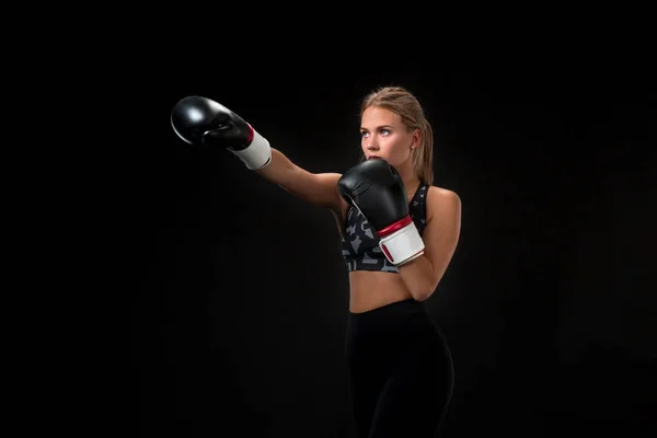 Hermosa atleta femenina en guantes de boxeo, en el estudio sobre un fondo negro . — Foto de Stock