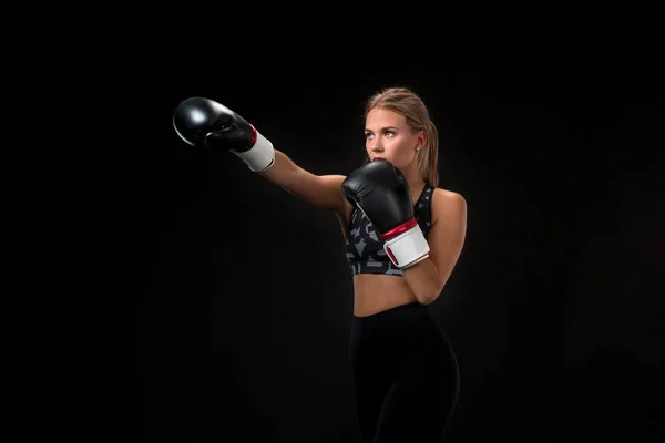 Schöne Athletin in Boxhandschuhen, im Studio auf schwarzem Hintergrund. — Stockfoto