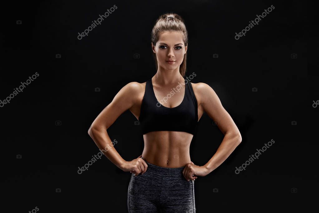 Bir kadeh spor giyim kas karın ile güçlü bir kadın. Fitness kadın model  siyah arka plan üzerine poz. stok fotoğrafçılık ©nazarov.dnepr@gmail.com,  telifsiz resim #174160554