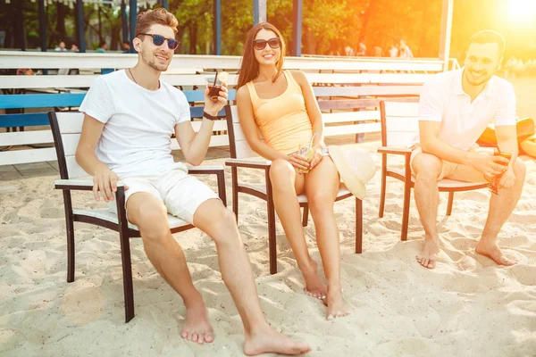 Young people enjoying summer vacation sunbathing drinking at beach bar