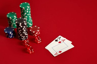 Poker fişleri ve kırmızı zemin üzerine as. Farklı poker fişleri grubudur. Casino arka plan.