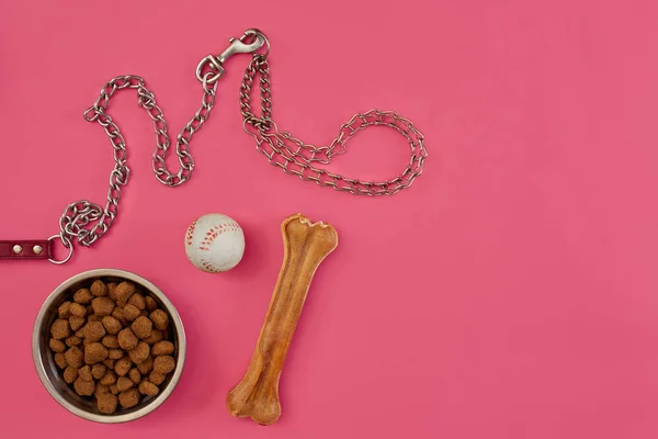 Alimentos para cães em tigela metálica e acessórios em fundo rosa — Fotografia de Stock