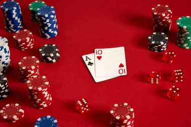 Poker kartları ve kırmızı zemin üzerine kumar fişleri