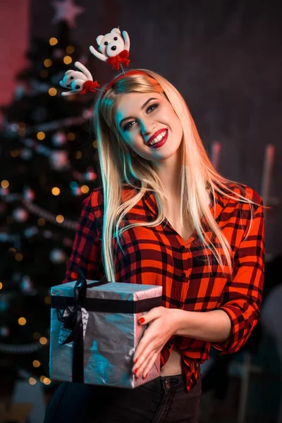 Navidad, x-mas, año nuevo, invierno, concepto de felicidad - mujer sonriente en sombrero de ayudante de santa con caja de regalo —  Fotos de Stock