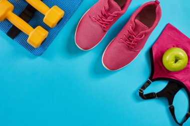 Sporcu kadın giyim ve halter ile parlak mavi arka plan ayarla