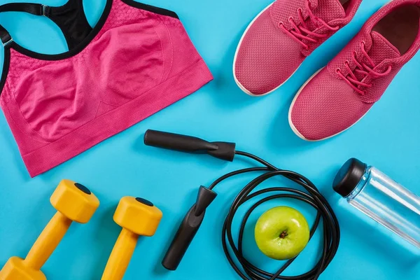 Kadın giyim, halter ve şişe suyu üzerinde parlak mavi arka plan ile sporcular ayarla