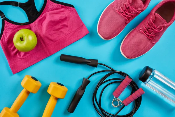 Kadın giyim, halter ve şişe suyu üzerinde parlak mavi arka plan ile sporcular ayarla