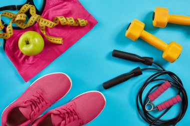 Kadın giyim, halter ve şişe suyu üzerinde parlak mavi arka plan ile sporcular ayarla