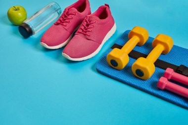 Sağlıklı kavramı, spor ayakkabı ve bir şişe su ve dumbell ile diyet planı mavi arka plan, sağlıklı yiyecek ve egzersiz kavramı