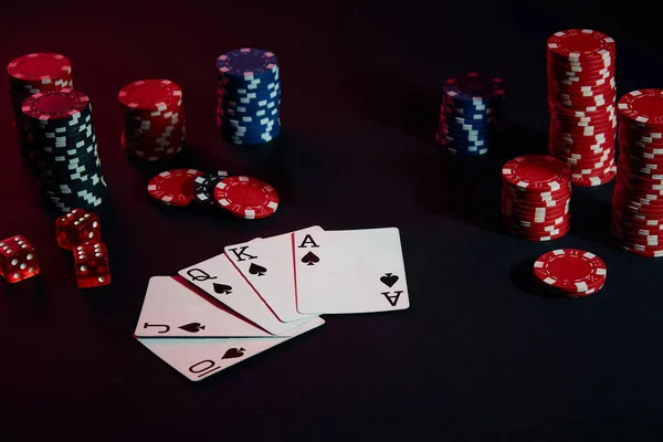 Casino chips and cards on black table surface. Gambling, fortune, game and entertainment concept - close up — Stock Photo, Image