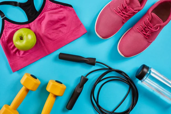 Kadın giyim, halter ve şişe suyu üzerinde parlak mavi arka plan ile sporcular ayarla