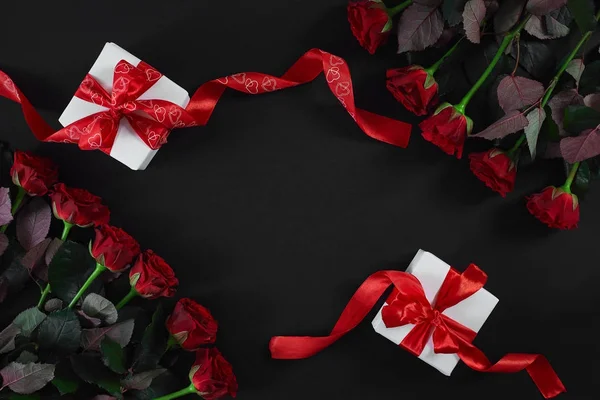 Witte geschenkdozen met rood lint op zwarte achtergrond. Valentijnsdag wenskaart. — Stockfoto