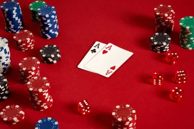 Poker kartları ve kırmızı zemin üzerine kumar fişleri