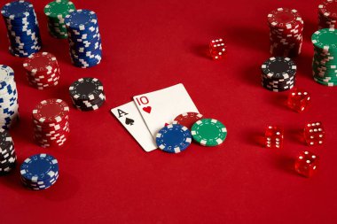 Poker kartları ve kırmızı zemin üzerine kumar fişleri