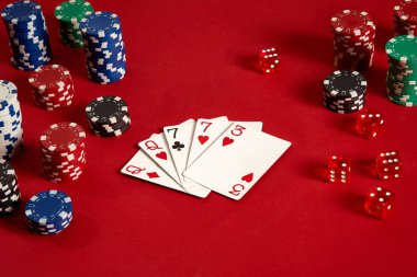 Poker kartları ve kırmızı zemin üzerine kumar fişleri