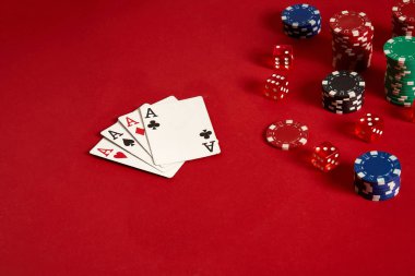 Poker kartları ve kırmızı zemin üzerine kumar fişleri