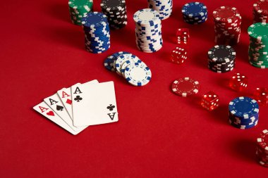 Poker kartları ve kırmızı zemin üzerine kumar fişleri