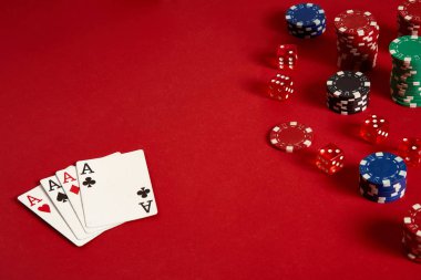 Poker kartları ve kırmızı zemin üzerine kumar fişleri