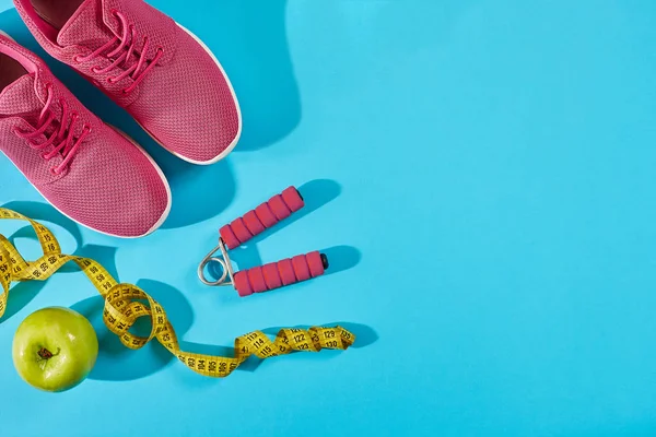 Sapatilhas com fita métrica em fundo azul ciano. Sapatos esportivos e equipamentos esportivos para forma saudável . — Fotografia de Stock