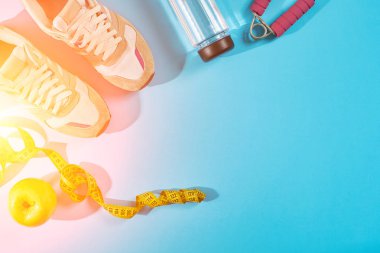 Teyp siyan mavi zemin üzerine ölçme ile spor ayakkabıları. Santimetre yakınında beyaz eğitimciler, sarı renkte kapatın. Güneş parlaması