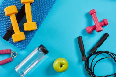 Halter, şişe su ve ip üzerinde mavi arka plan atlama. Üstten Görünüm. Fitness, spor ve sağlıklı yaşam konsepti.