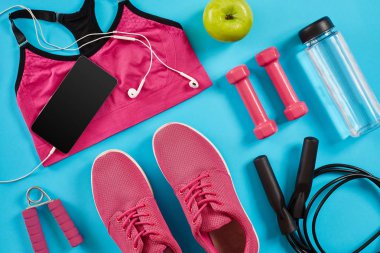 Kadın giyim, halter ve şişe suyu üzerinde parlak mavi arka plan ile sporcular ayarla