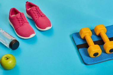 Sağlıklı kavramı, spor ayakkabı ve bir şişe su ve dumbell ile diyet planı mavi arka plan, sağlıklı yiyecek ve egzersiz kavramı