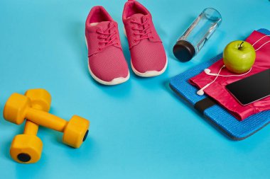 Sağlıklı kavramı, spor ayakkabı ve bir şişe su ve dumbell ile diyet planı mavi arka plan, sağlıklı yiyecek ve egzersiz kavramı