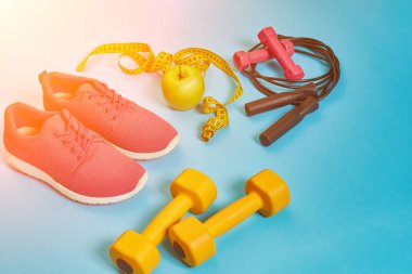 Halter, şişe su, ip atlama ve spor ayakkabı düz yatıyordu, spor aletleri, fitness öğeleri, görünümü en iyi. Güneş parlaması