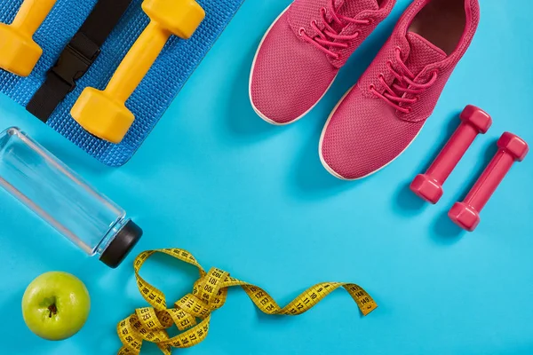 Kadın giyim, halter ve şişe suyu üzerinde parlak mavi arka plan ile sporcular ayarla