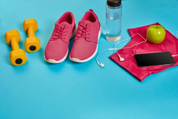 Gesundes Konzept, Ernährungsplan mit Sportschuhen und Wasserflasche und Hanteln auf blauem Hintergrund, gesundes Essen und Bewegungskonzept — Stockfoto