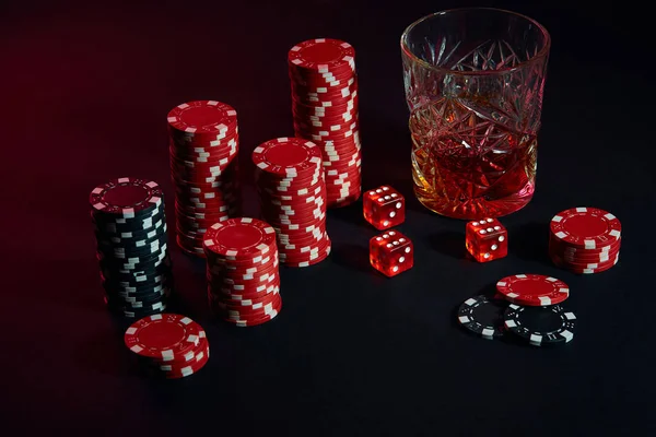 Fichas de póquer y copa de vino de coñac en la mesa oscura. Juegos de azar — Foto de Stock