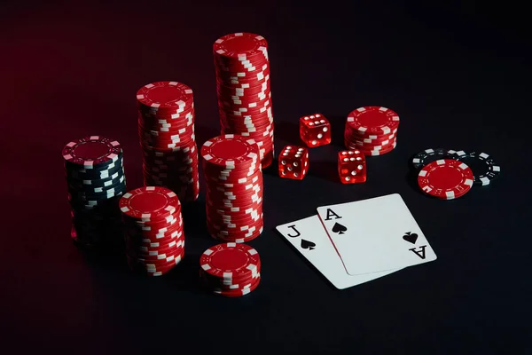 Red and black chips for gambling and playing cards on black background — Stock Photo, Image