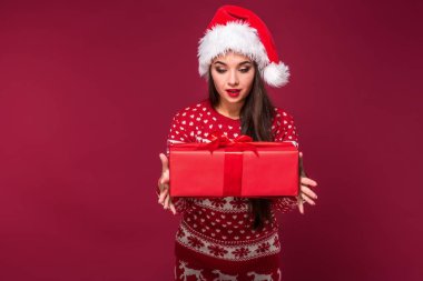 Noel hediyesi ellerinde kırmızı studio arka planda tutan genç güzel kadın