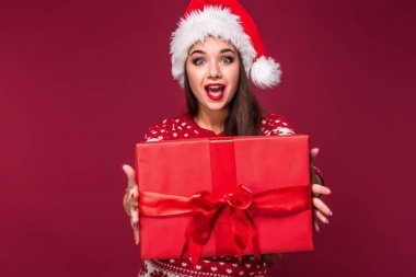 Noel hediyesi ellerinde kırmızı studio arka planda tutan genç güzel kadın