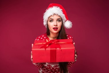 Noel hediyesi ellerinde kırmızı studio arka planda tutan genç güzel kadın
