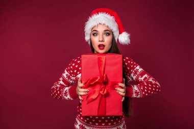 Noel hediyesi ellerinde kırmızı studio arka planda tutan genç güzel kadın