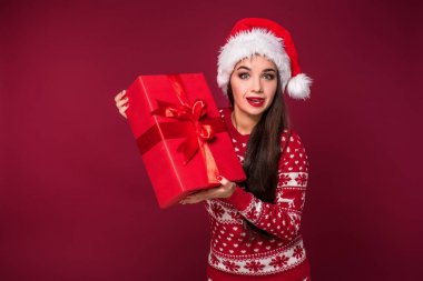 Noel hediyesi ellerinde kırmızı studio arka planda tutan genç güzel kadın