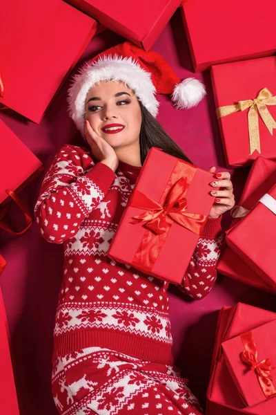 Śmieszne młoda kobieta w sukni New Years, leżącego na górze prezenty. — Zdjęcie stockowe