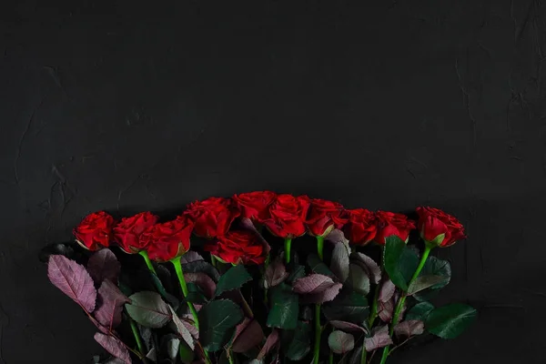 Ramo de rosas rojas sobre fondo negro. Vista superior — Foto de Stock