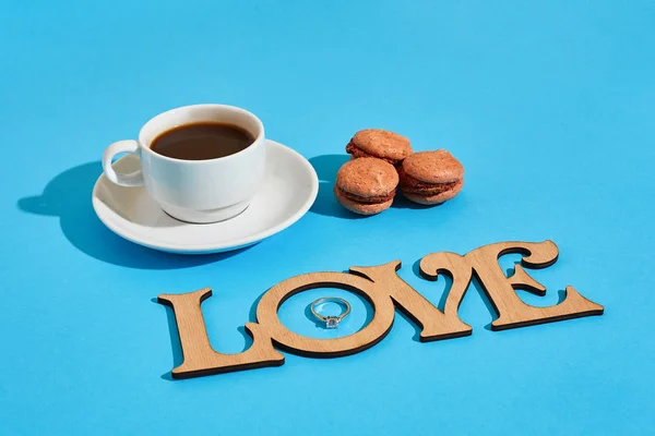 Macarons doces saborosos e xícara de café. Macaroons em fundo azul — Fotografia de Stock