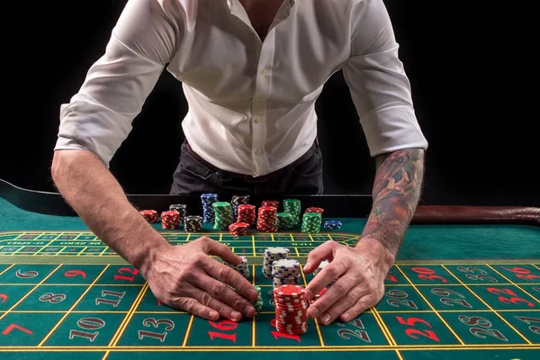 Ein lebendiges Bild von grünem Casino-Tisch mit Roulette, mit den Händen von Croupier und bunten Chips. — Stockfoto