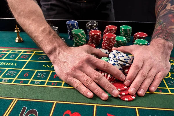 Una imagen vibrante de primer plano de la mesa de casino verde con ruleta, con las manos de croupier y fichas multicolores . — Foto de Stock