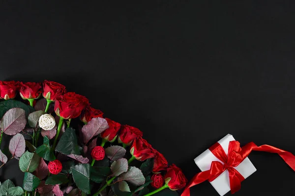 빨간 장미와 검은 바탕에 빨간 리본을 가진 백색 선물 상자 — 스톡 사진
