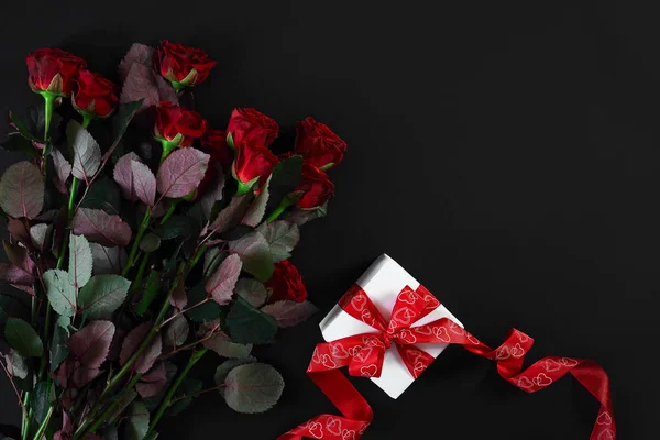 Rode rozen, ring en gift box op zwarte achtergrond — Stockfoto