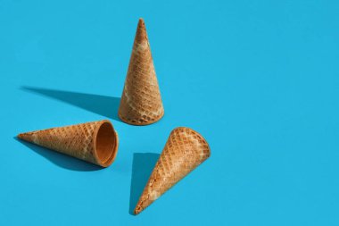 Üç gözleme dondurma koni ile mavi bir arka plan üzerinde gölge