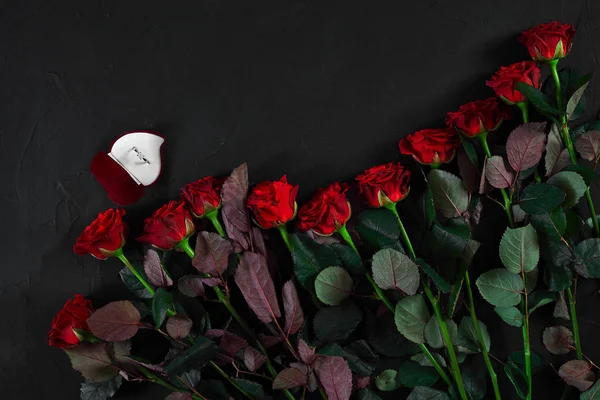 Un ramo de rosas rojas y una caja de anillos. Vista superior — Foto de Stock