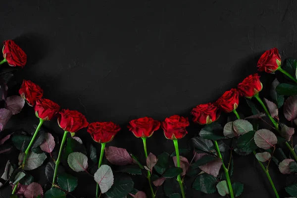 Buquê de rosas vermelhas sobre um fundo preto. Vista superior — Fotografia de Stock