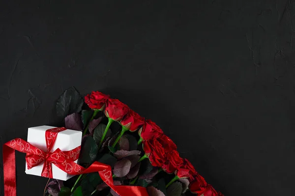 상위 뷰 신선한 빨간 장미 꽃과 선물 상자 e와 검은 갑판에 — 스톡 사진
